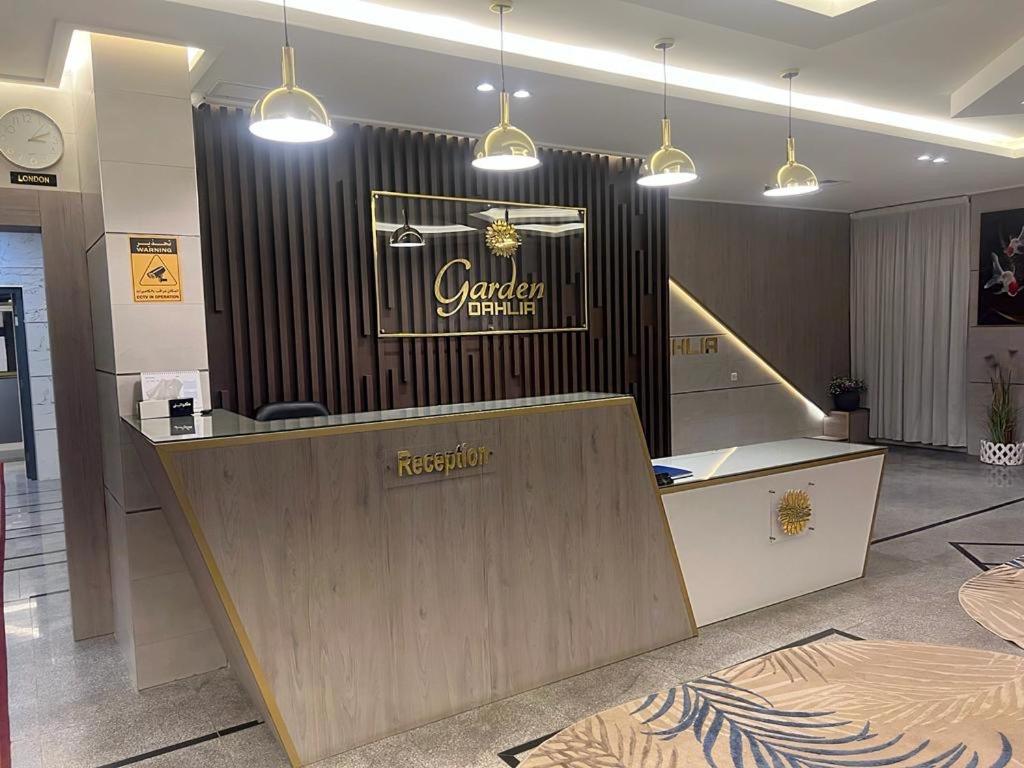 Garden Dahlia Hotel Apartment - Formerly Regency Dahlia - Farwaniya في الكويت: لوبى به كونتر وعلامة على الحائط