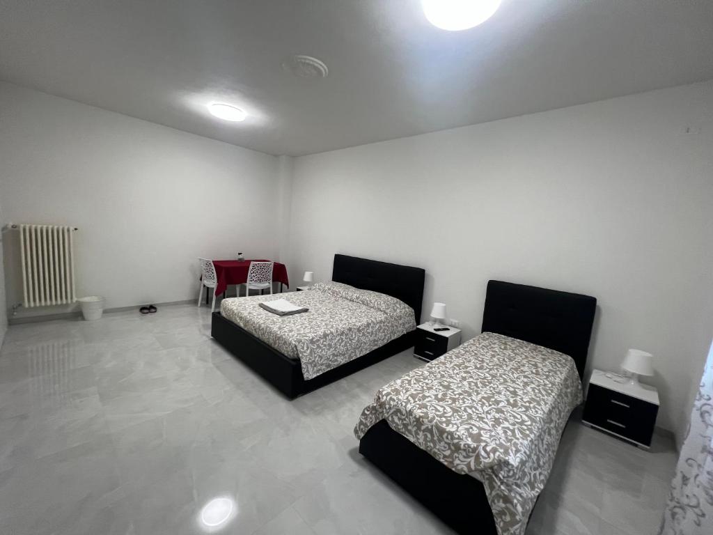 um quarto com duas camas e uma mesa em Casa Roma rooms&apartments em Pádua