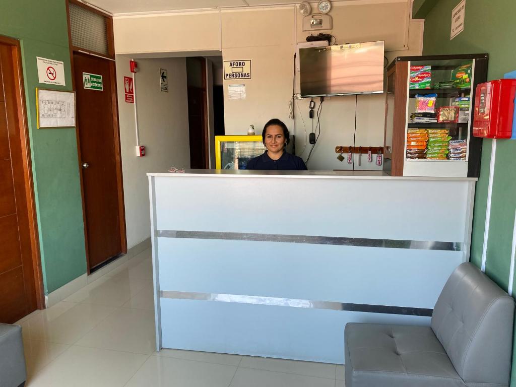 a woman standing behind a counter in a hospital at LATORRE HOSTAL in Jaén