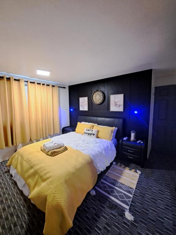 1 dormitorio con 1 cama grande con manta amarilla en Professional Stay Doctors Nurses Trades en Luton