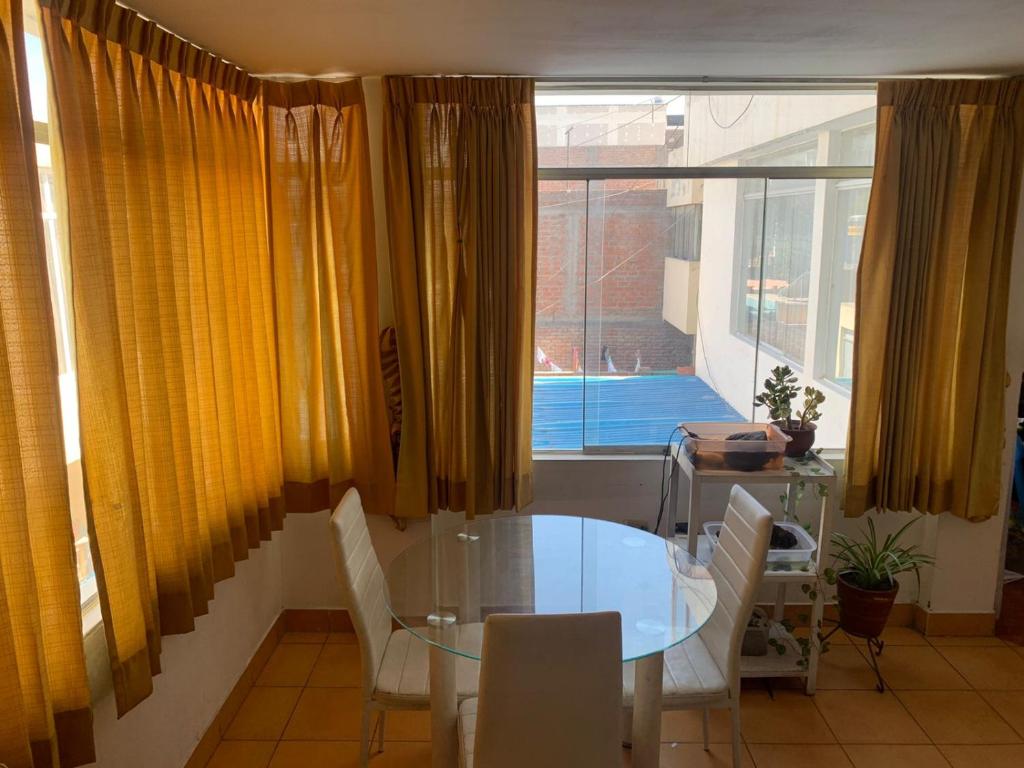 een eetkamer met een tafel en stoelen en een raam bij Casa por tecsup in Paucarpata