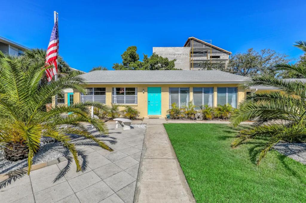 una casa con una bandera americana delante de ella en Tropical Pelican Beach Home en Clearwater Beach