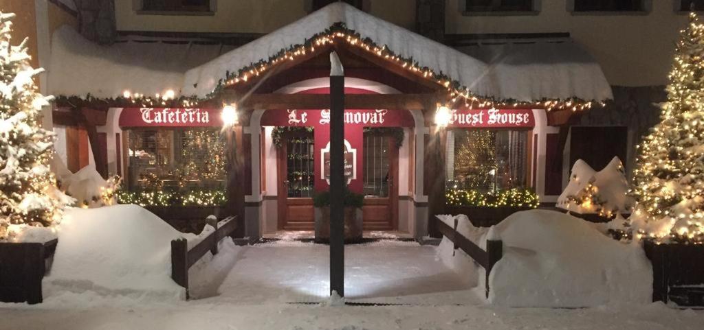 a store front with christmas lights in the snow at Le Samovar Guest House in Breuil-Cervinia