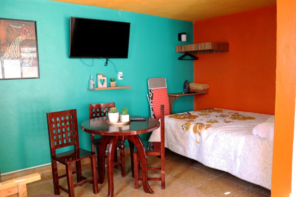 Cette chambre comprend un lit, une table et des chaises. dans l'établissement Sensity Home Recámara amplia y muy céntrica, à Tehuacán