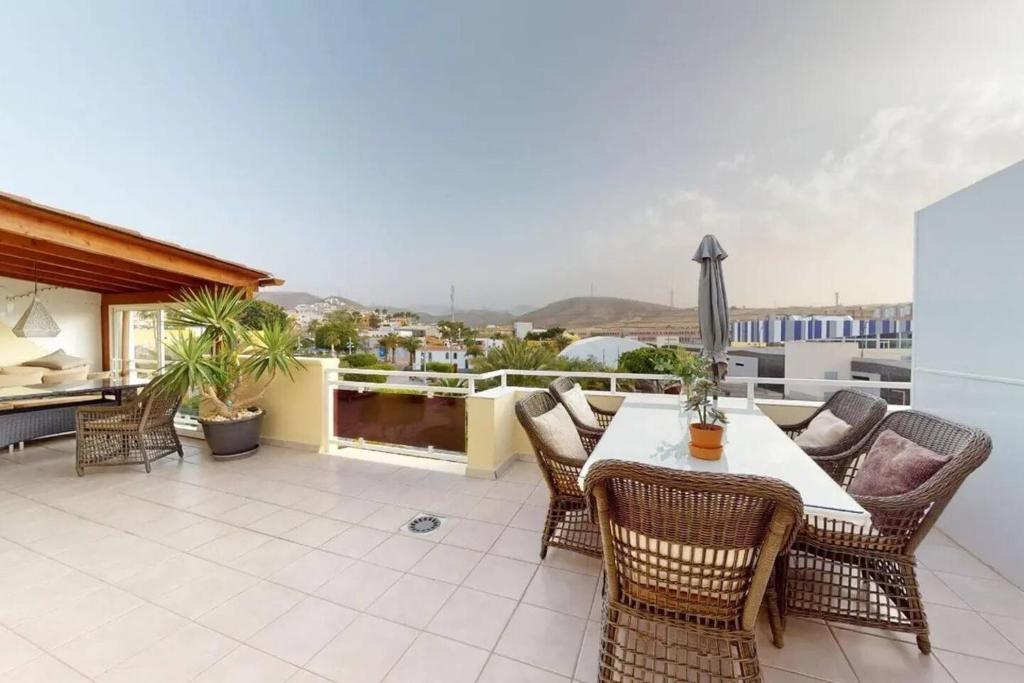 a patio with a table and chairs on a balcony at Perchel Sport in Las Palmas de Gran Canaria