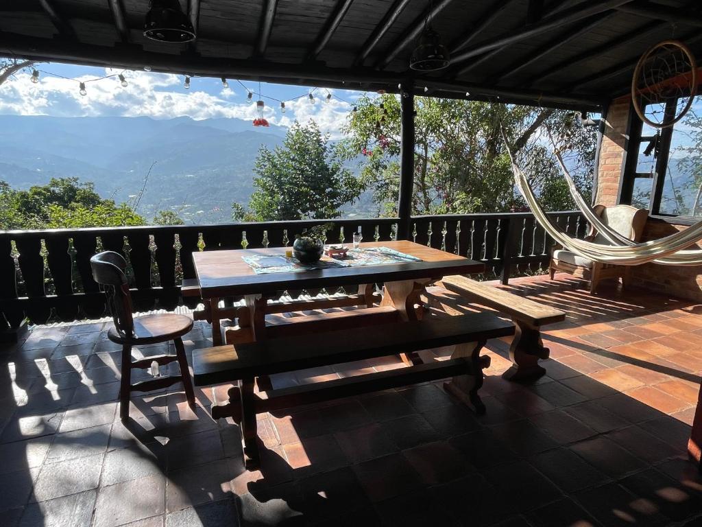 a patio with a table and chairs and a swing at Refugio Explora Verde in Choachí