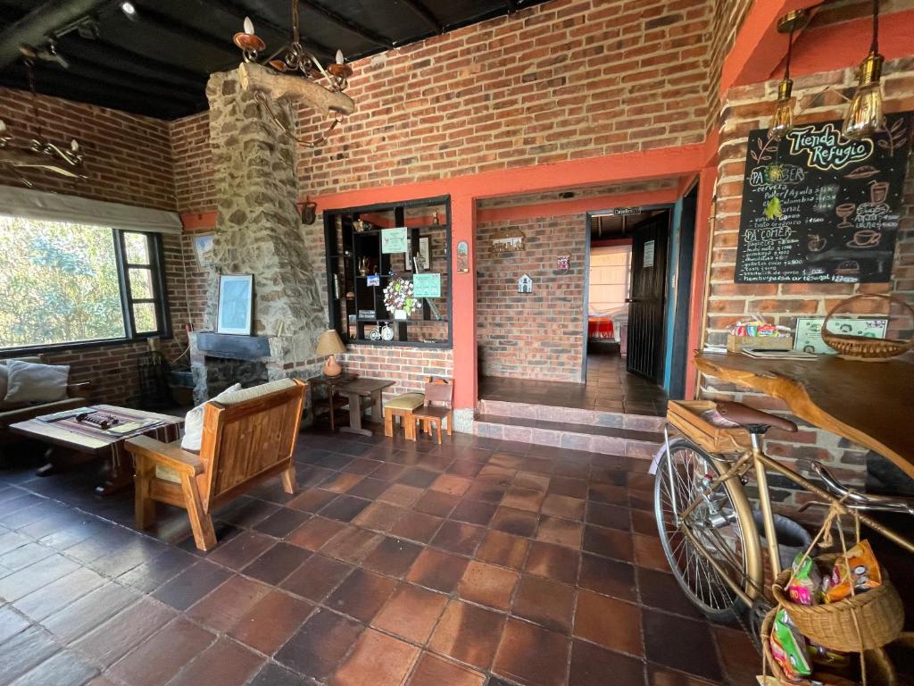 a living room with a brick wall and a bike at Refugio Explora Verde in Choachí