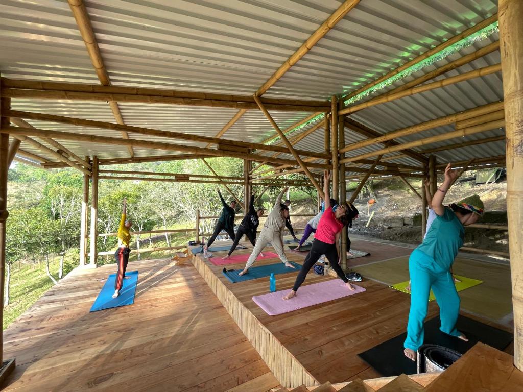 a group of people doing a yoga pose on mats at Refugio Explora Verde in Choachí