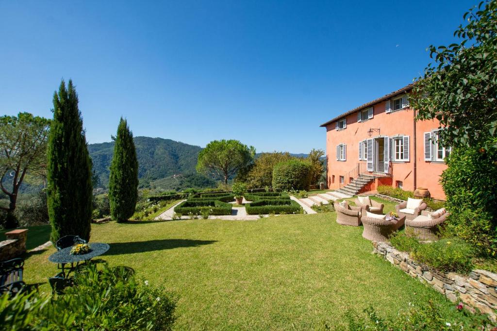 a large yard with chairs and a building at Villa Igea in Mastiano