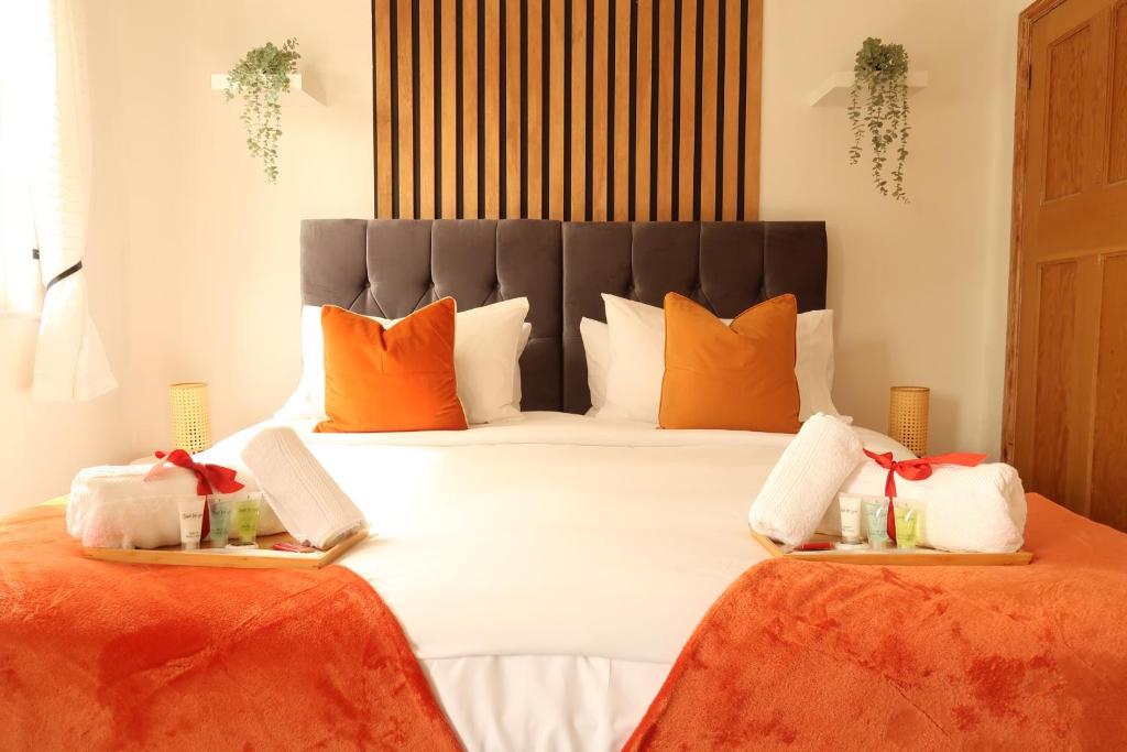 Cosy home in London في لندن: غرفة نوم مع سرير كبير مع وسائد برتقالية