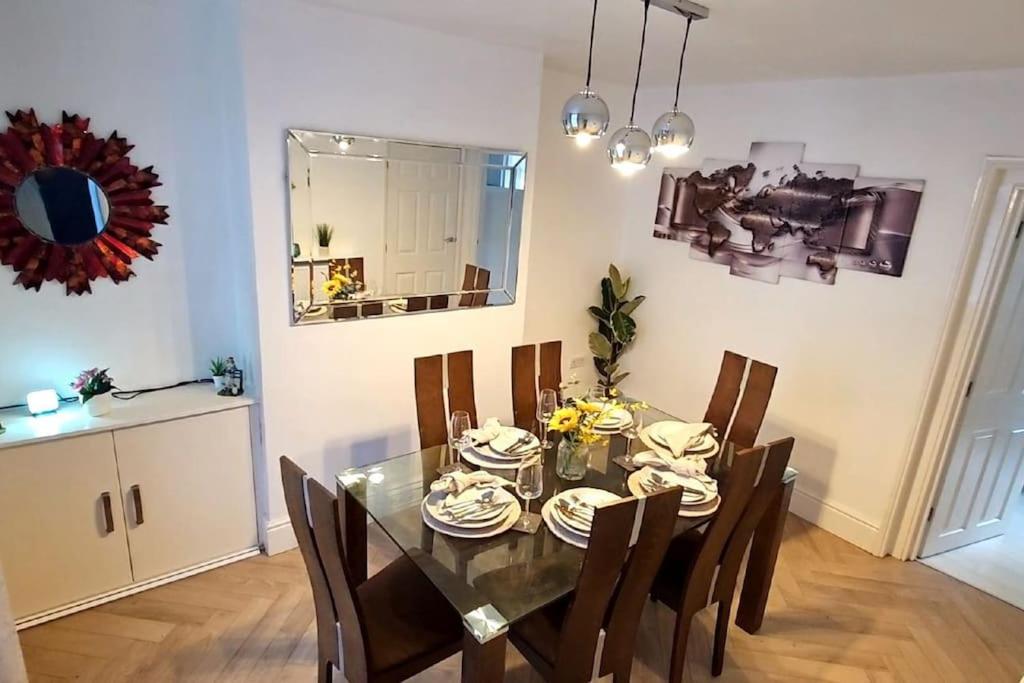 a dining room with a glass table and chairs at Alfred House in Ripley