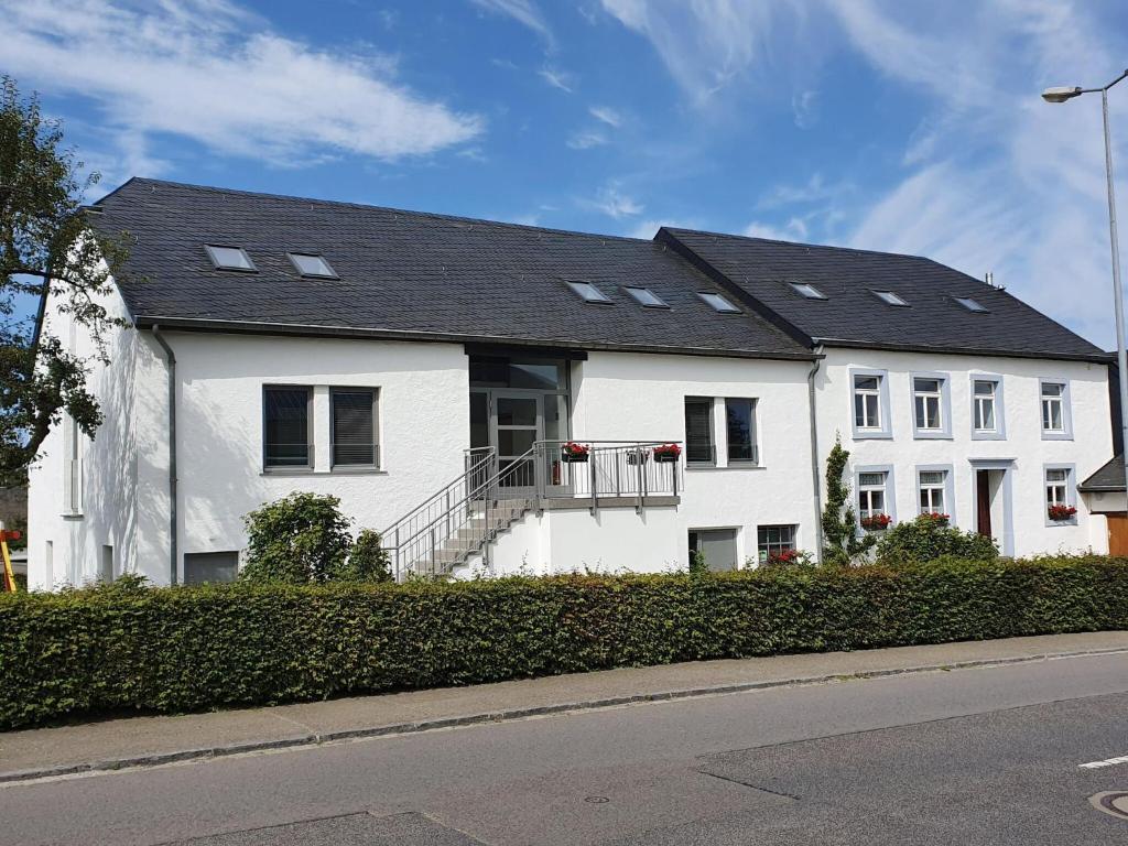 une maison blanche avec un toit noir dans l'établissement Luxury Family Holiday Home with Wellness, à Binsfeld