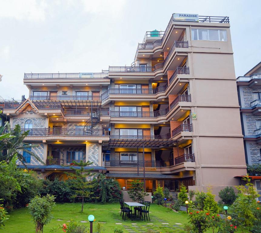 um edifício de apartamentos com um jardim em frente em Paradise Boutique Hotel em Pokhara