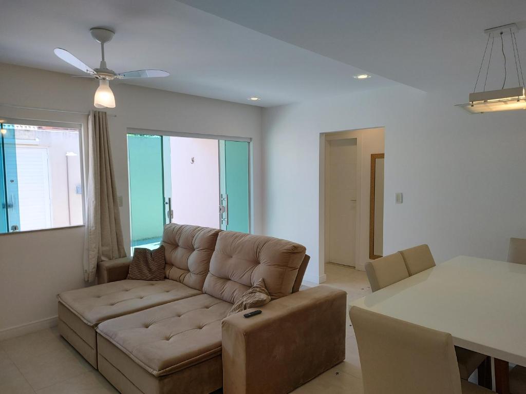 a living room with a couch and a table at Casa Sol Nascente in Cabo Frio
