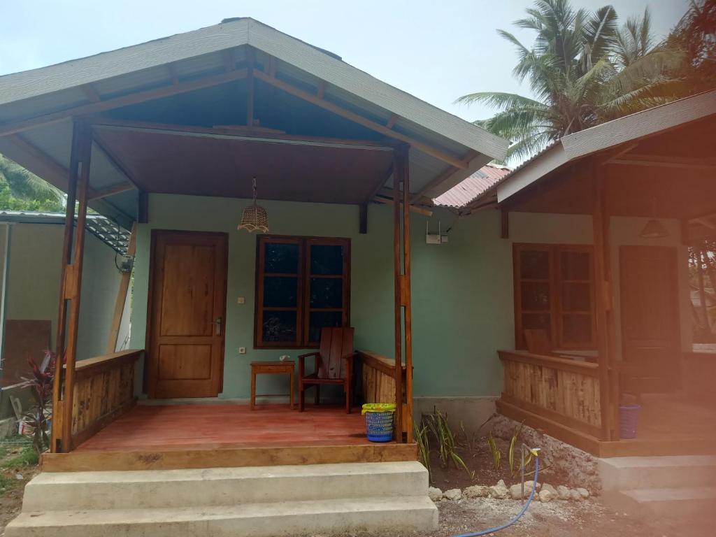 a small house with a porch and a door at Renata Cottage in Langgur