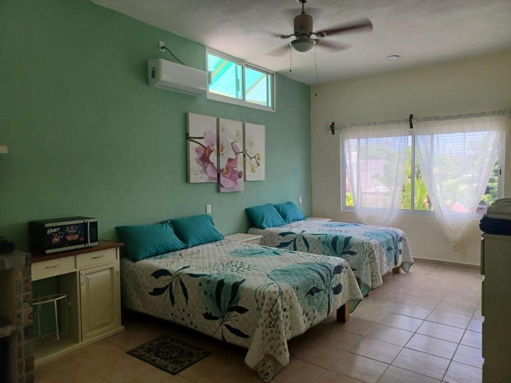 a bedroom with two beds and a ceiling fan at Casa Amelia in San Blas