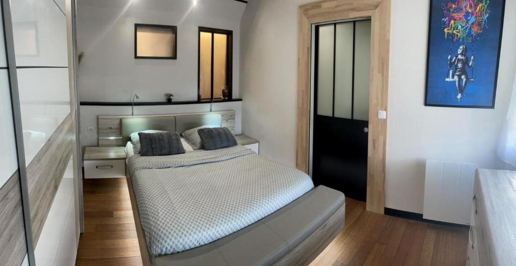 Schlafzimmer mit einem Bett und einem Spiegel in der Unterkunft L'Interlude, tout confort et équipé pour une escale entre terre et mer in Calais