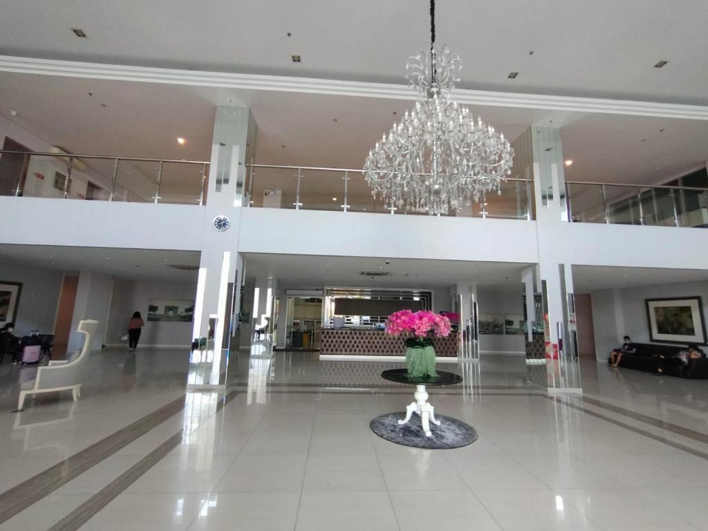 un'ampia hall con lampadario a braccio e vaso di fiori di Apartemen Pakuwon Educity yale a Surabaya
