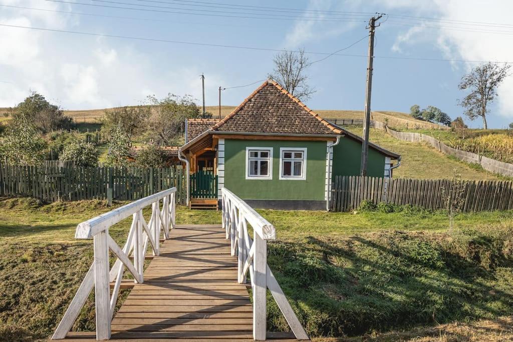 una pequeña casa verde con un puente de madera en Casa Johann, your charming holiday home in Cund, en Cund