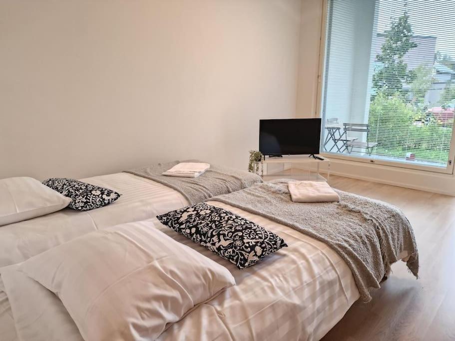 two beds sitting next to each other in a room at Cozy apartment with a yard in Kivistö near Airport in Vantaa