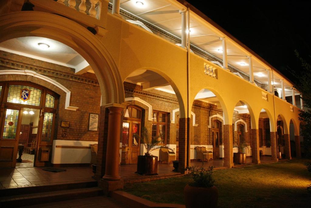a building with an archway in front of it at night at Kimberley Club Guesthouse in Kimberley