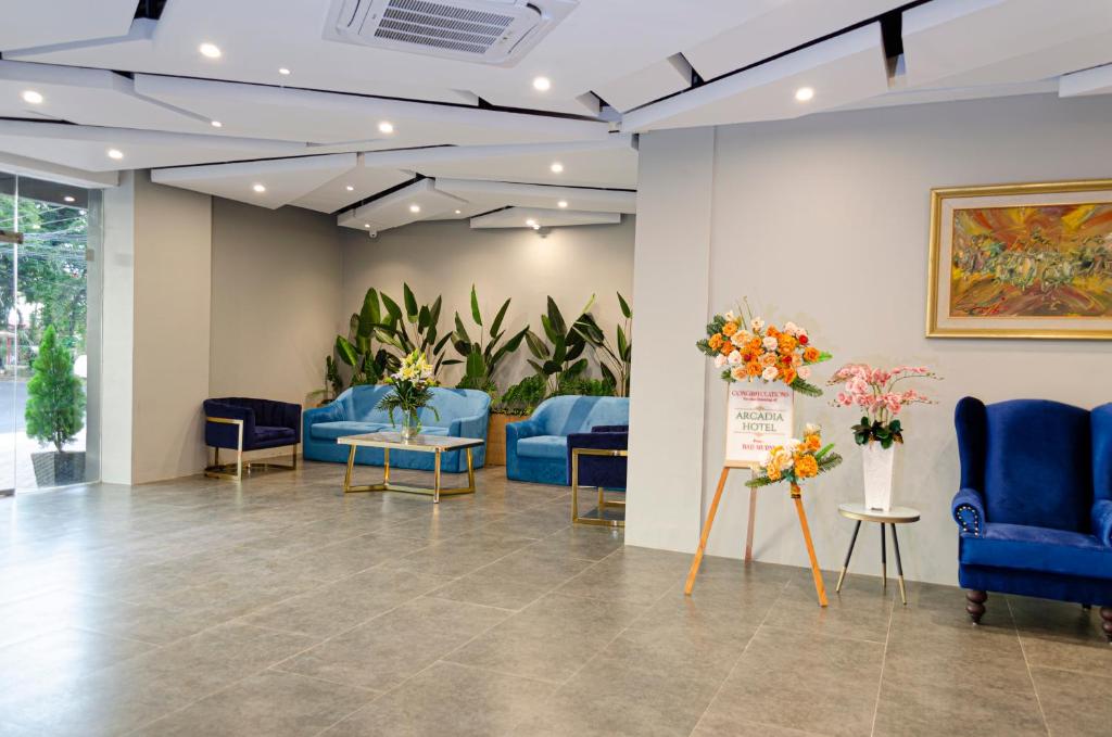 una sala de espera con sillas azules y flores en Arcadia Hotel Manado, en Manado