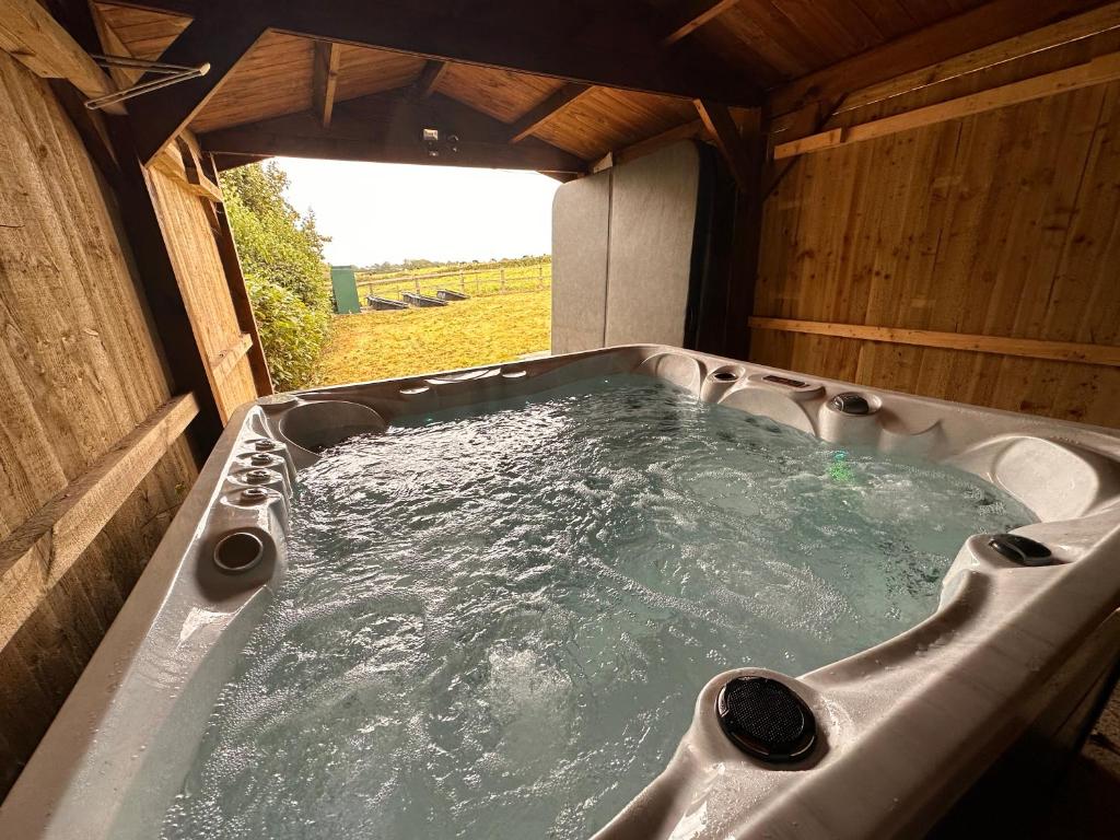 una bañera de hidromasaje en una casa de madera en Hot Tub & GF Bedroom in Countryside Holiday Home, en Chippenham