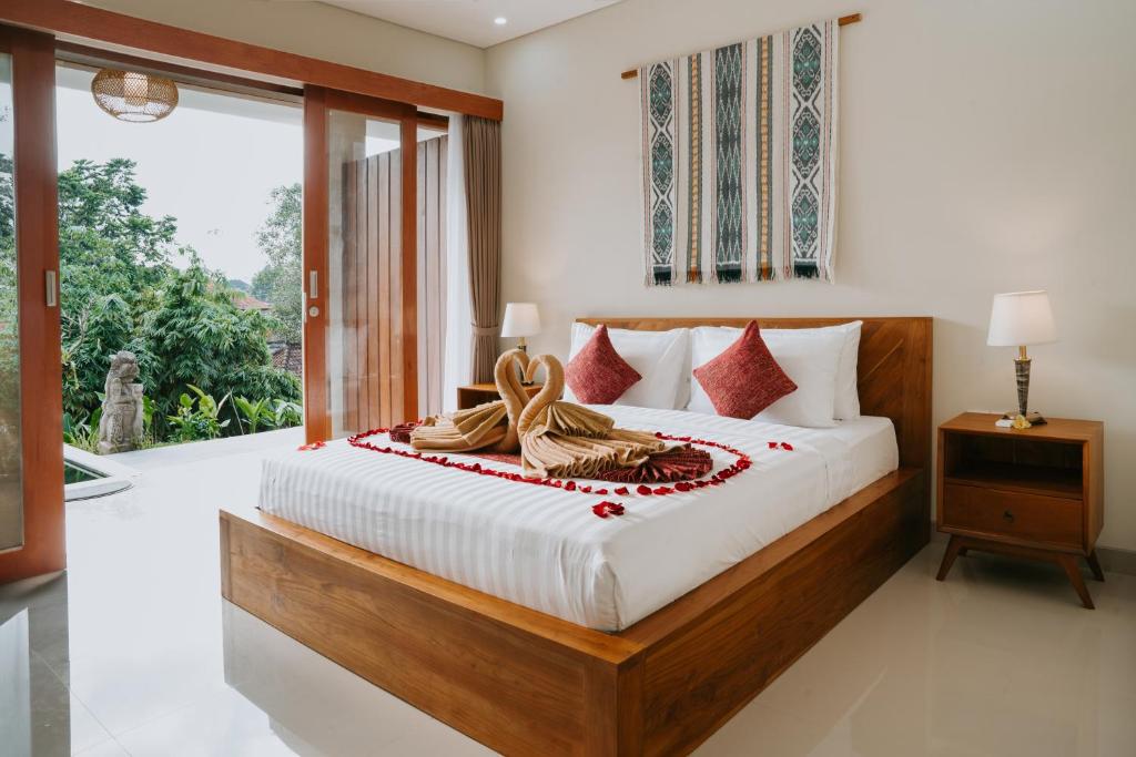 um quarto com uma cama e uma grande janela em Sanubari Ubud em Ubud