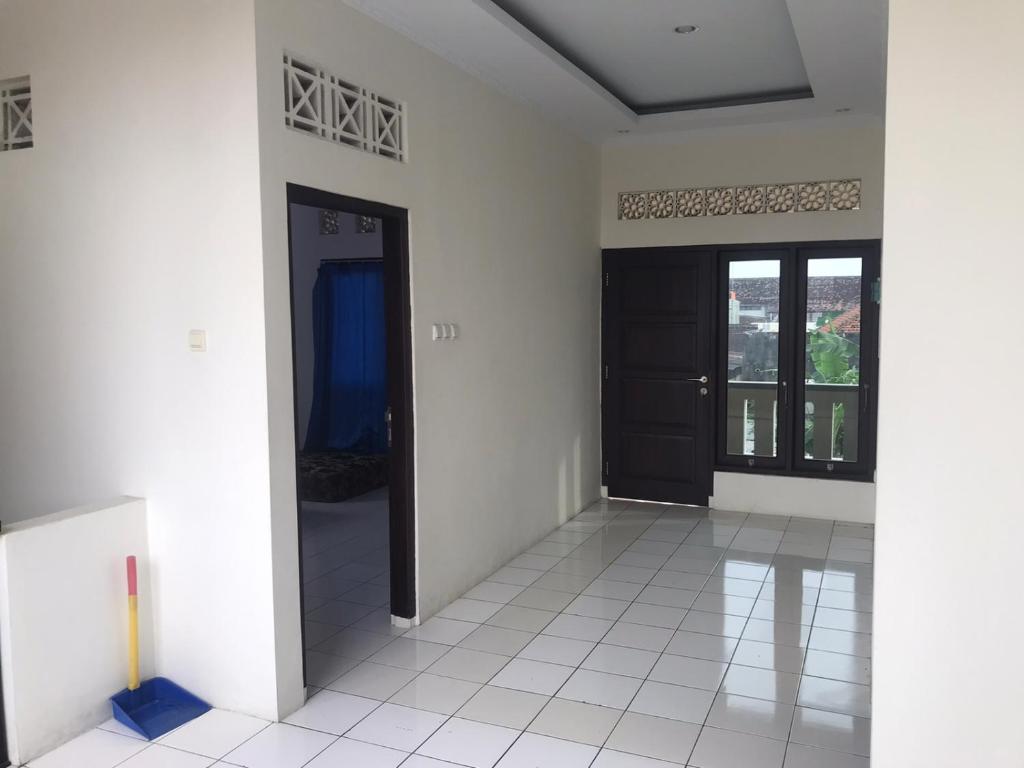 a room with a black door and a white tile floor at VILLA BUDI HUTAMA in Jetis