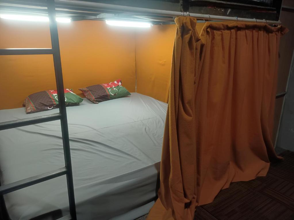 泗水的住宿－Rubikz Hostel & Cafe，一间卧室配有一张双层床和梯子