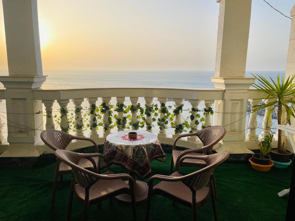 a table and chairs on a balcony with the ocean at Fourth star in Alexandria