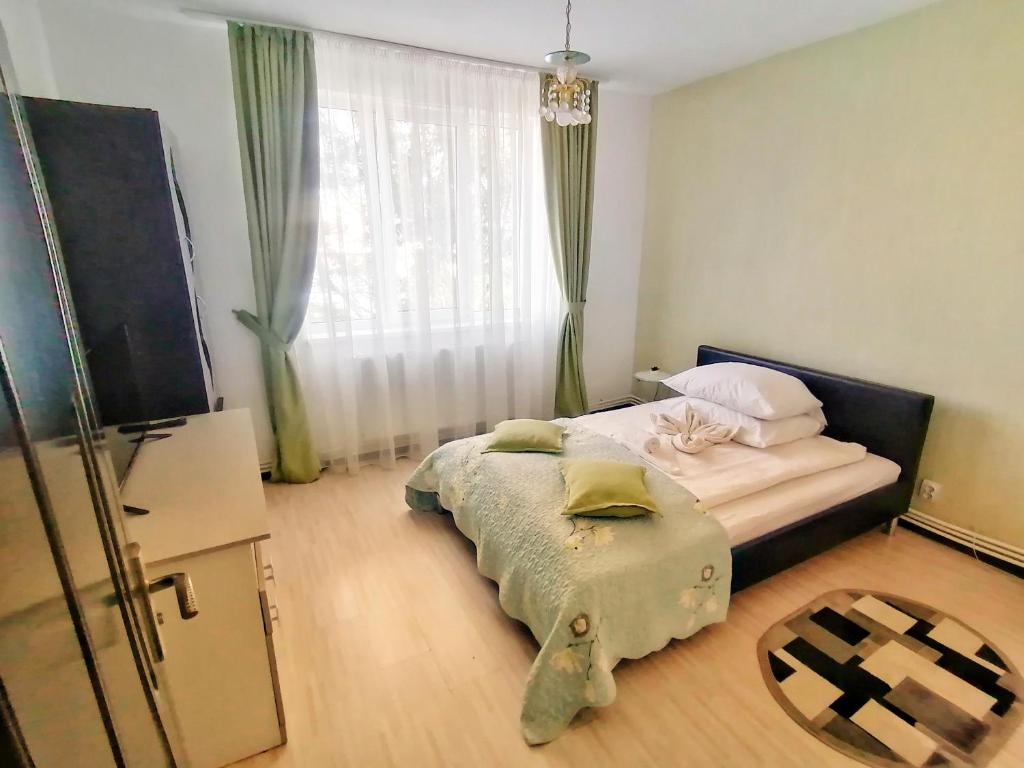 um pequeno quarto com uma cama e uma janela em Apartament Anita em Vulcan