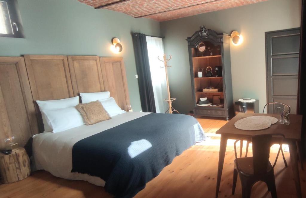 1 dormitorio con cama, mesa y espejo en Coeur de ferme en Pévèle 