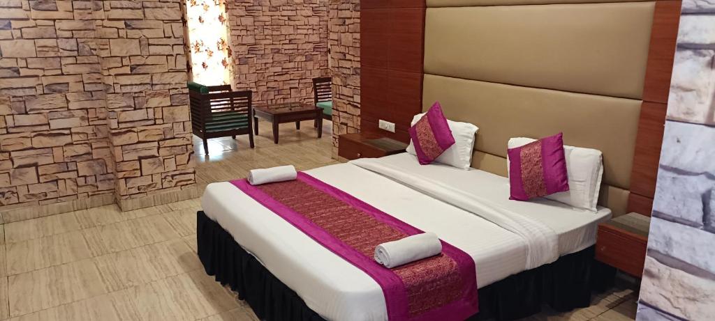 a bedroom with a large bed with purple pillows at The mirage in Ludhiana