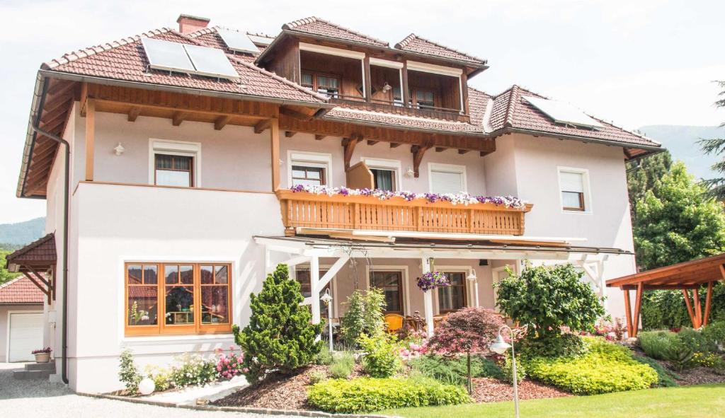 a house with a balcony on top of it at Seeappartements Bacher in Seeboden