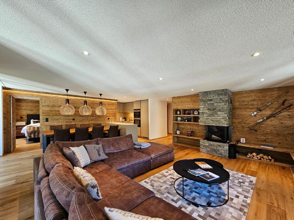 a living room with a couch and a fireplace at Riverside 3rd Floor North in Saas-Fee