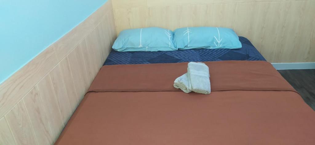 Cama pequeña en habitación con almohadas azules en cozy place in texas, en Pemulutan-hilir