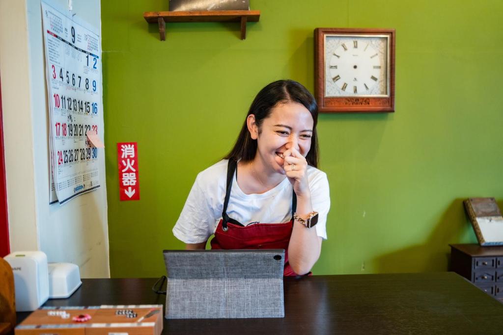 una mujer sentada en una mesa con la mano en la cara en M&Unity, en Okinawa City