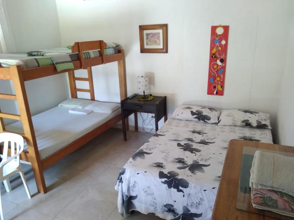 a bedroom with two bunk beds and a table at Casa Hostal Arena de Mar in Necoclí