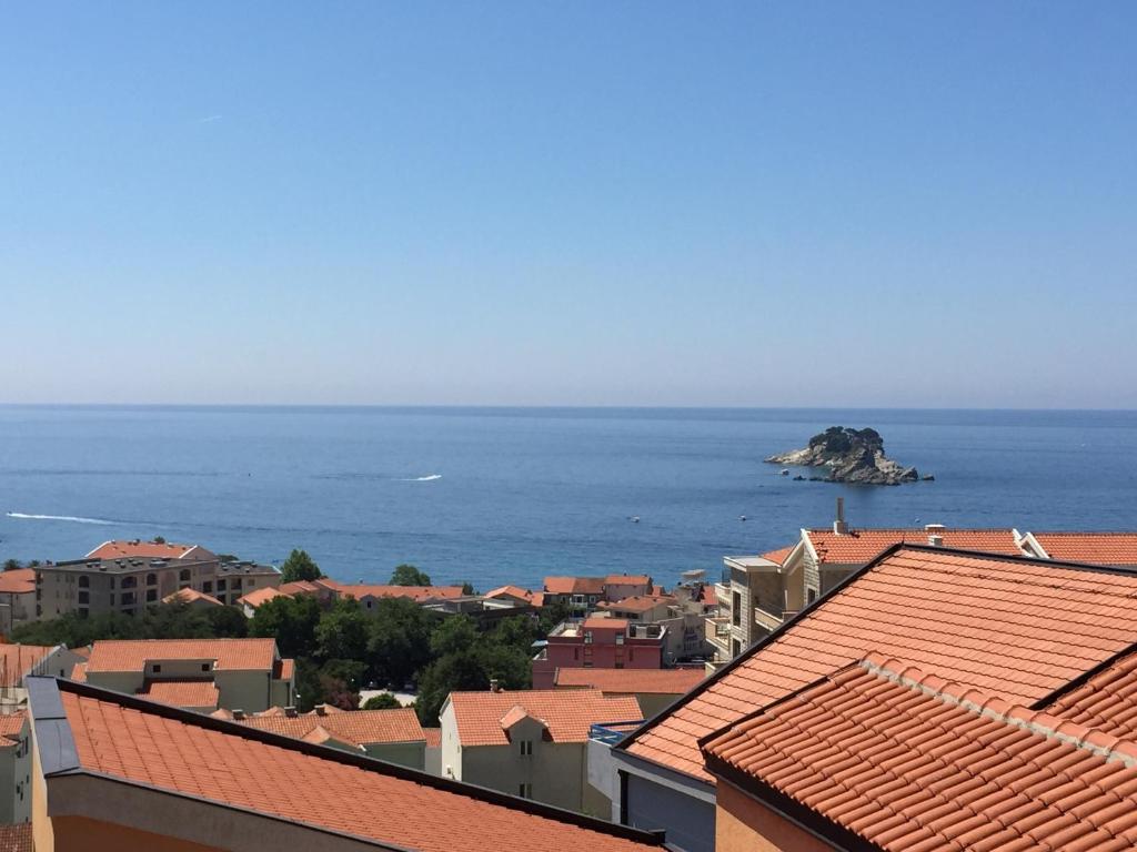 a view of the ocean from the roofs of buildings at Apartments Ivan in Petrovac na Moru