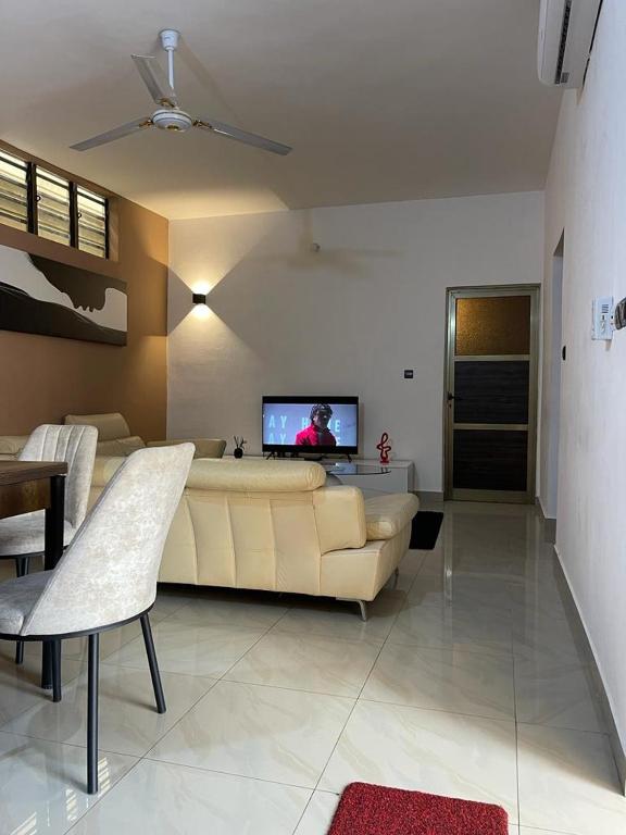 uma sala de estar com um sofá e uma televisão de ecrã plano em Agimhote 