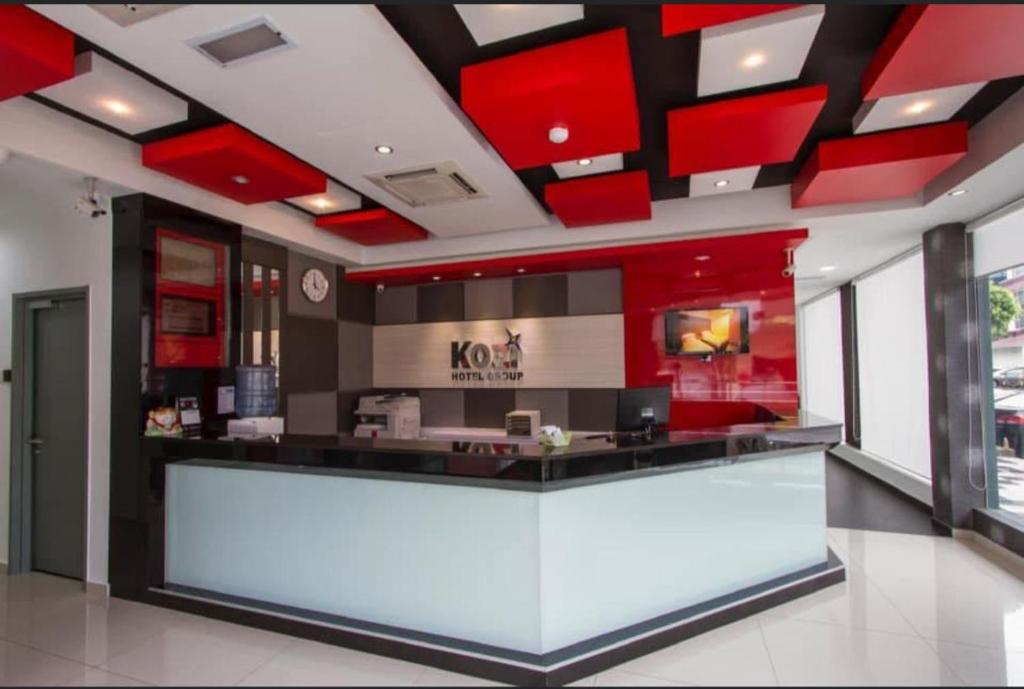 a restaurant with red cabinets and a counter at Kozi Hotel - Bukit Indah in Johor Bahru
