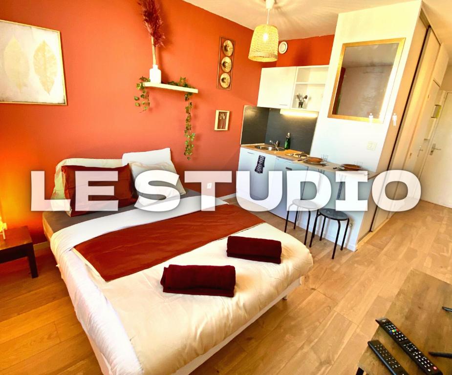 sypialnia z łóżkiem z pomarańczową ścianą w obiekcie Splendide studio Moderne - Proche centre - Laverie w mieście Nîmes