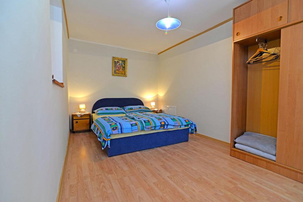 a bedroom with a bed with a blue comforter at Kobale 1 in Veli Lošinj