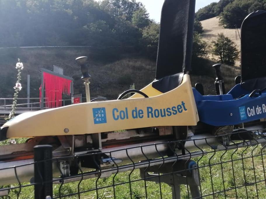 a train on a track with a sign on a fence at petit nid montagnard in Rousset