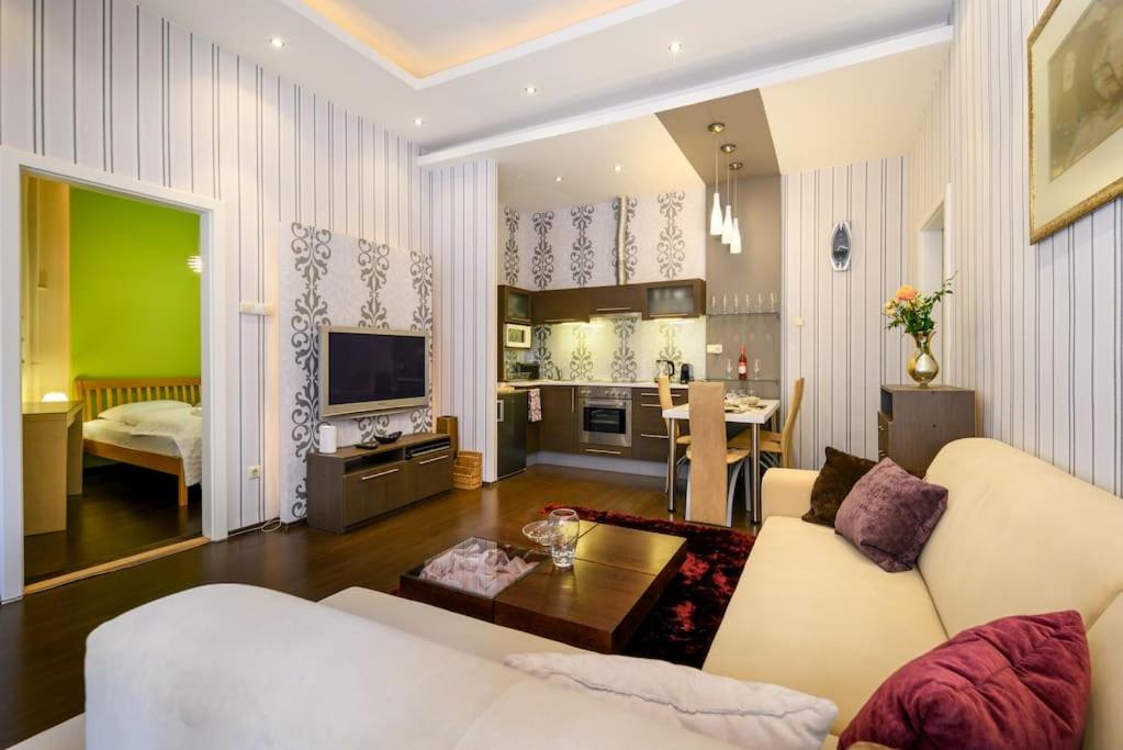 sala de estar con sofá blanco y cocina en Chrysoprase Apartment, en Budapest