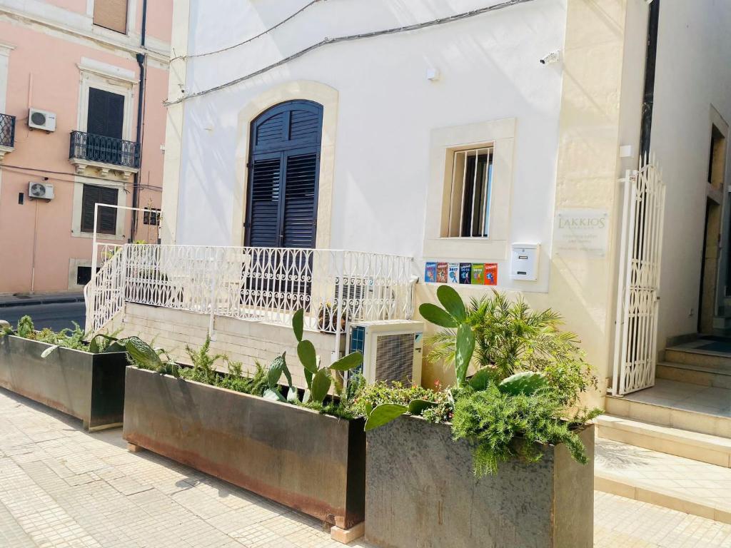 una fila de plantas en una acera frente a un edificio en Lakkios charming suites and rooms, en Siracusa