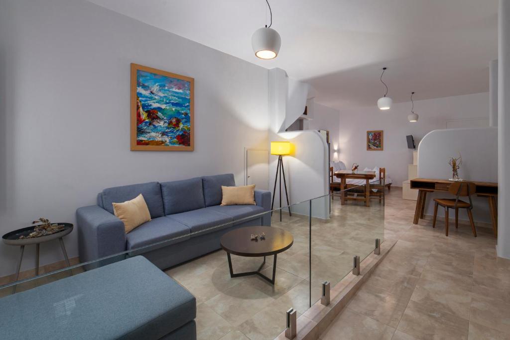 a living room with a blue couch and a table at Andros 4 All Seasons Villas & Suites in Andros
