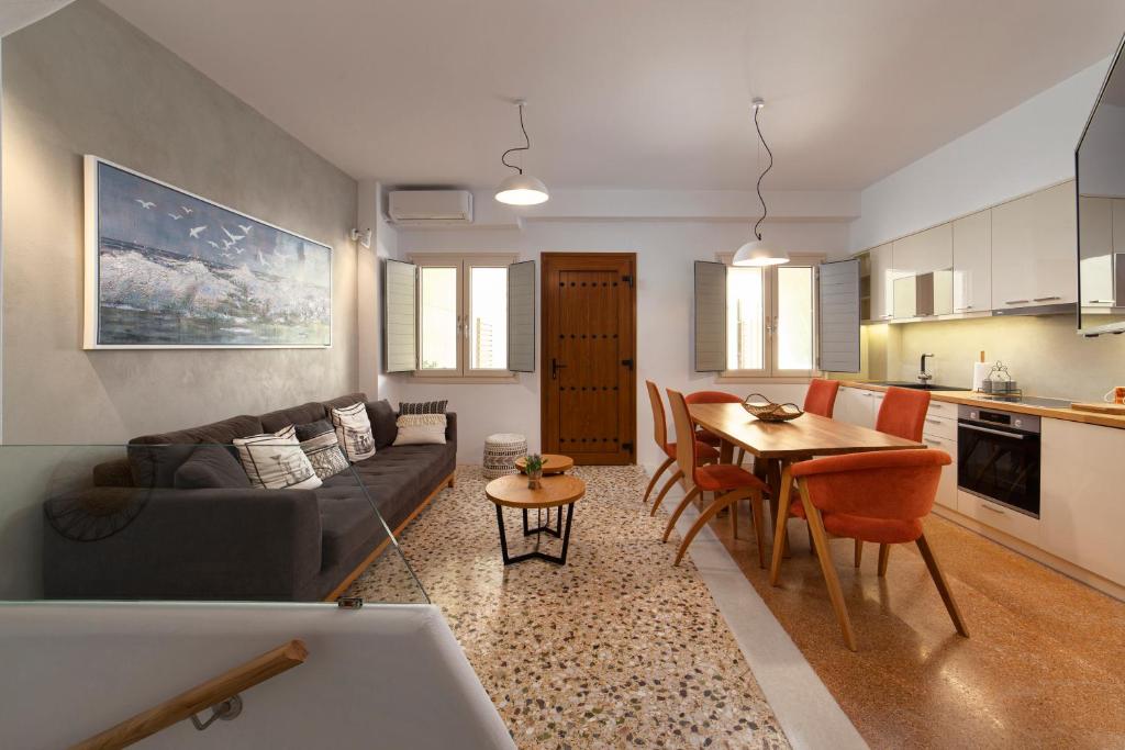 a living room and kitchen with a couch and a table at Andros 4 All Seasons Villas & Suites in Andros