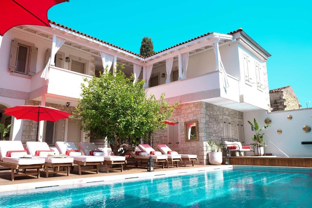 a villa with a swimming pool and patio furniture at Viento Alacati Hotel in Alacati